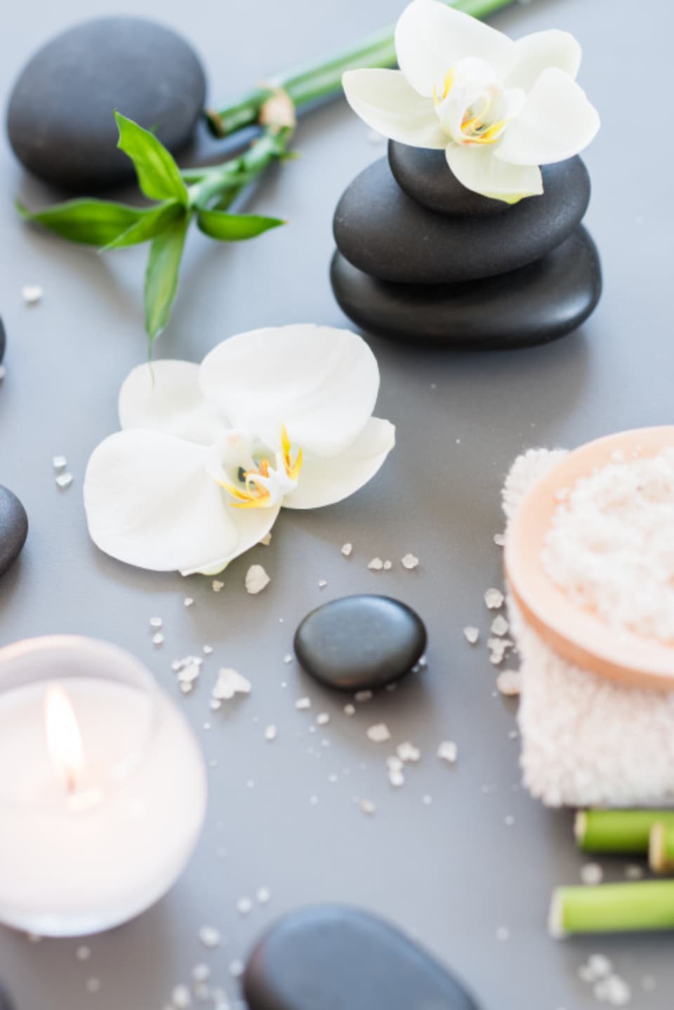 Warm stones, salt and an orchid on a spa tray